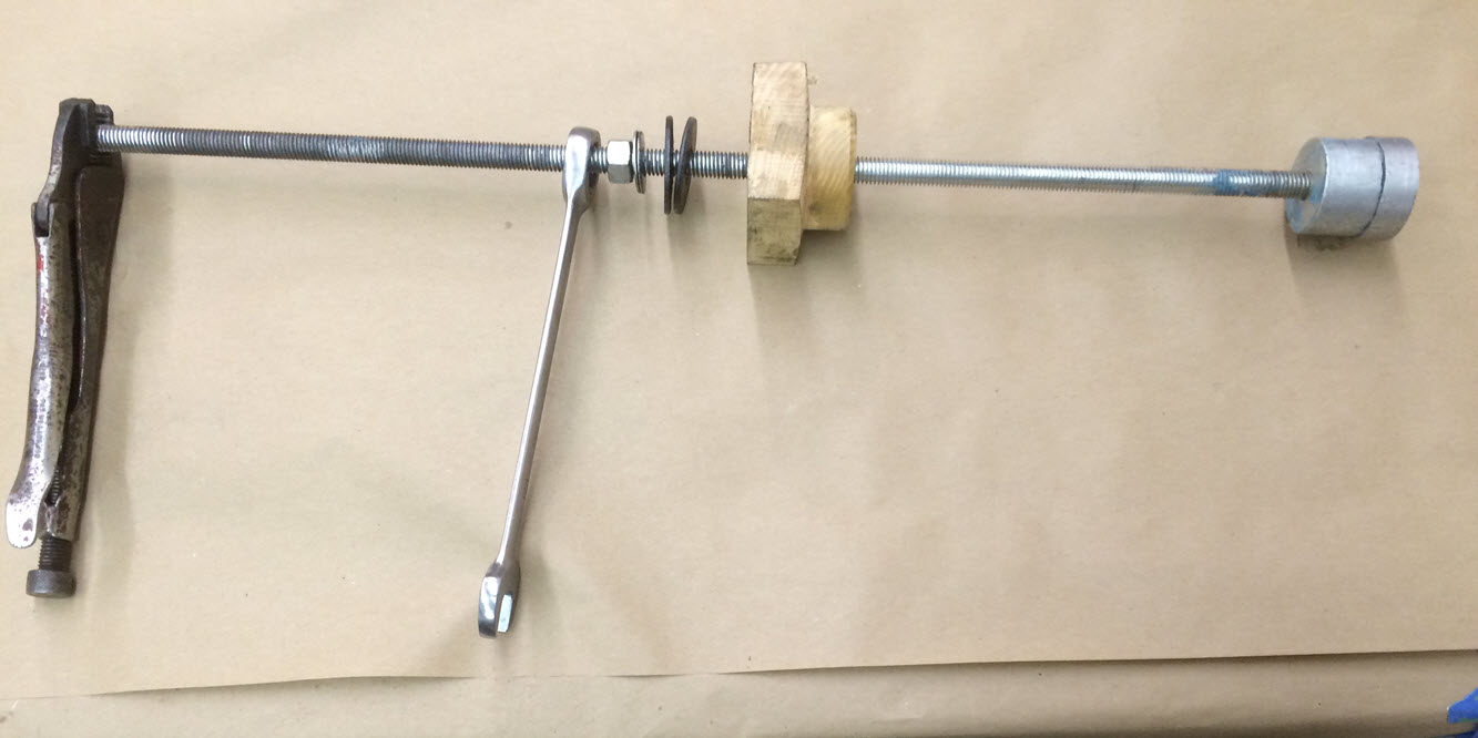 Cam bearing tool. 1/2" threaded rod, a nut, wood centering insert for top bearing and an aluminum bearing holder.